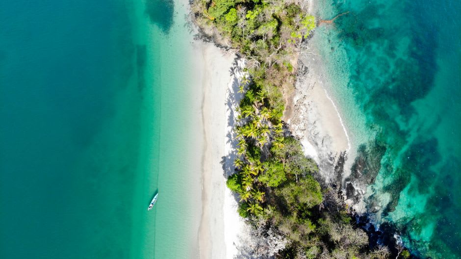 A small boat weaving between forested, uninhabited islands in the Gulf of Chiriquí near Boca Chica