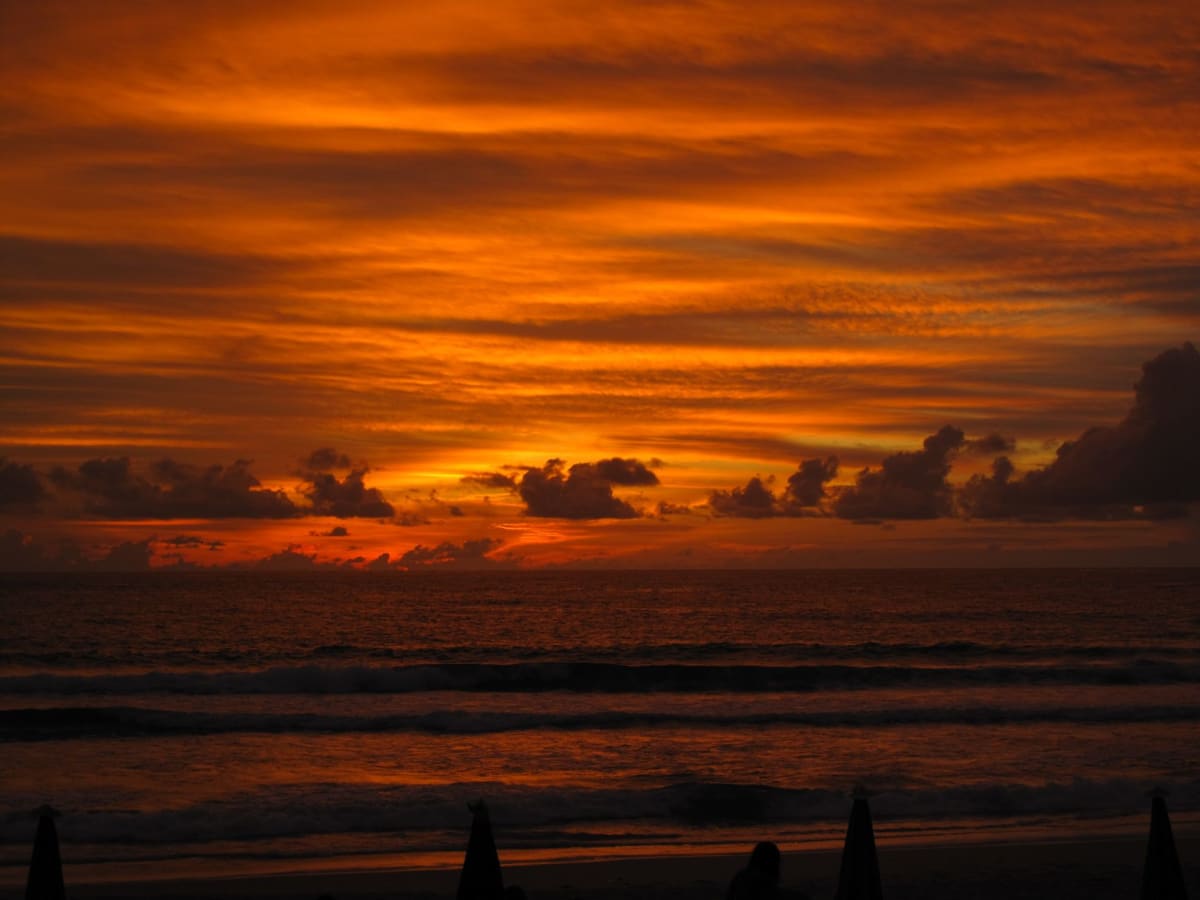 Karon Beach's pale, squeaking sand at the waterline, the gentle slope into flat turquoise water
