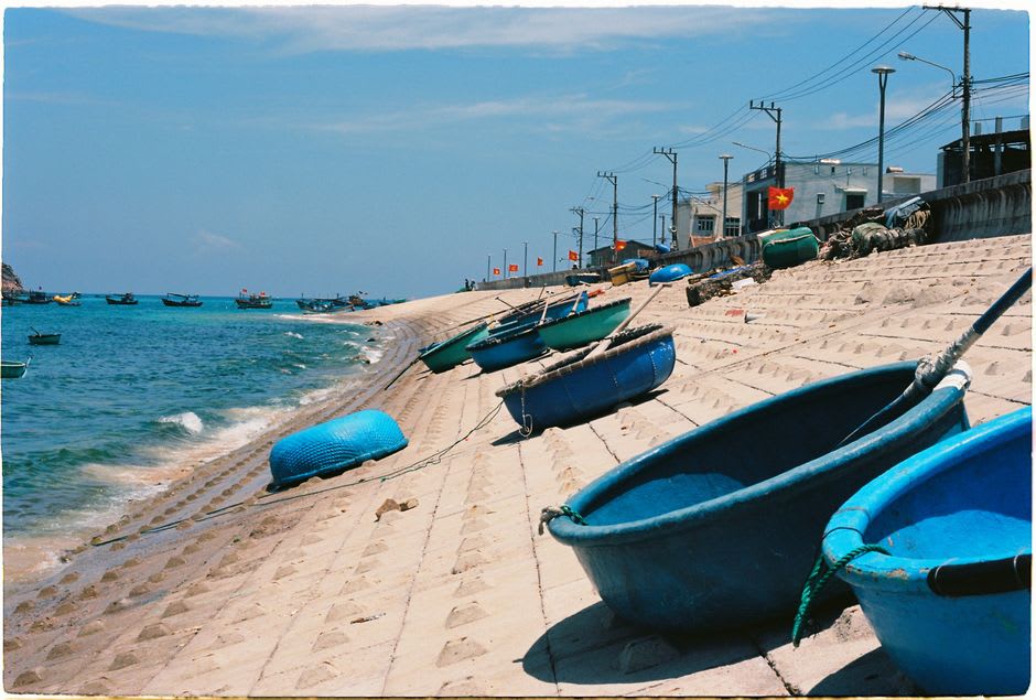 Wide sandy path through Culatra's fishing village with small colorful houses and drying nets