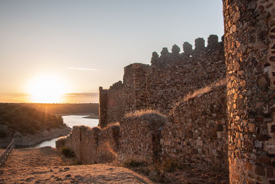 The Guadiana river at dusk seen from Mértola's castle walls with storks flying overhead