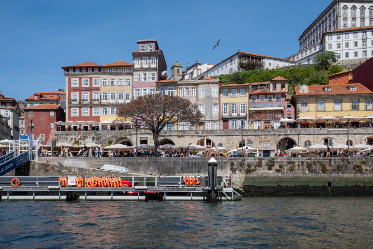 Colourful azulejo-tiled facades and granite houses lining the Ribeira waterfront above the Douro