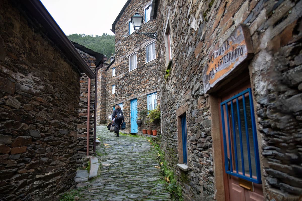 Narrow schist lane in Candal village, moss-covered walls catching afternoon light