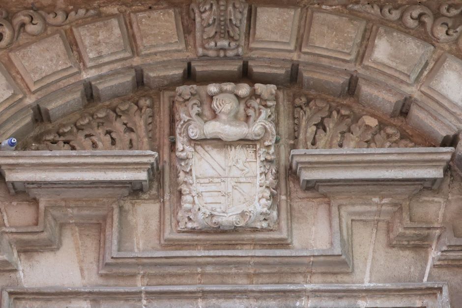 Carved granite doorway with a worn family crest on a manor house facade in Provesende