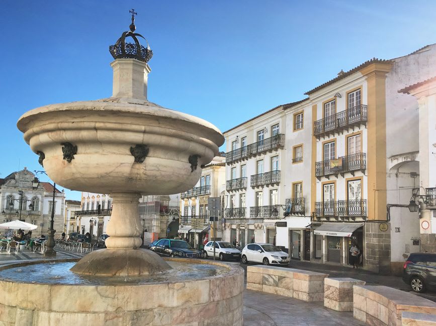 Fuente de mármol en una tranquila plaza empedrada de Vila Viçosa al atardecer