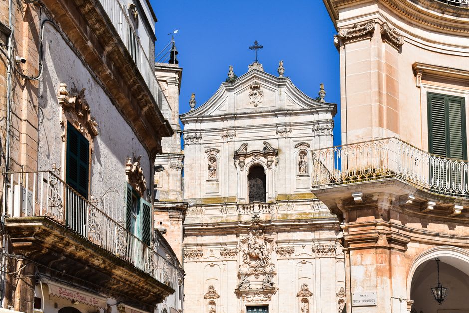 Vista de los tejados y cúpulas de las iglesias de Martina Franca desde el borde del pueblo, con olivares a lo lejos