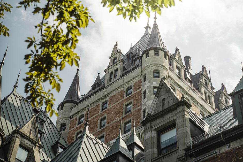 De la neige saupoudrant la terrasse en contrebas du Château Frontenac, avec le fleuve Saint-Laurent gelé visible au loin