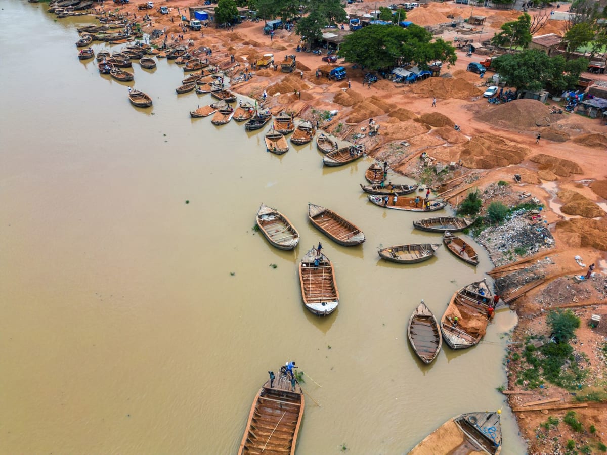 El puerto de Mopti a primera hora de la mañana, hombres cargando piraguas con mercancías mientras el Níger capta la primera luz