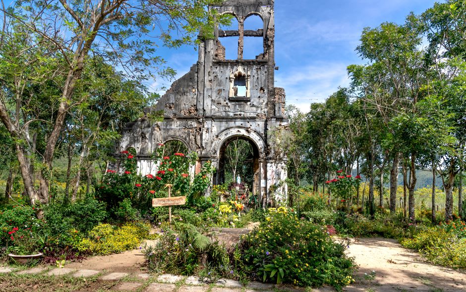 Ruinas de piedra de la antigua casa de la plantación de Romney Manor cubiertas de flores tropicales y enredaderas