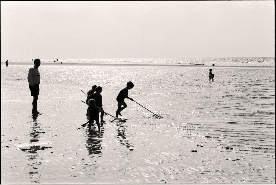 Niños jugando a lo largo de la orilla en la playa de Lefaga a última hora de la tarde