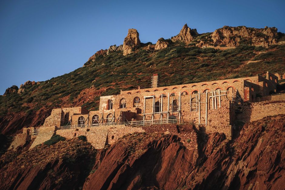 The dramatic cliffside opening of Porto Flavia's mining tunnel framing the sea below near Iglesias