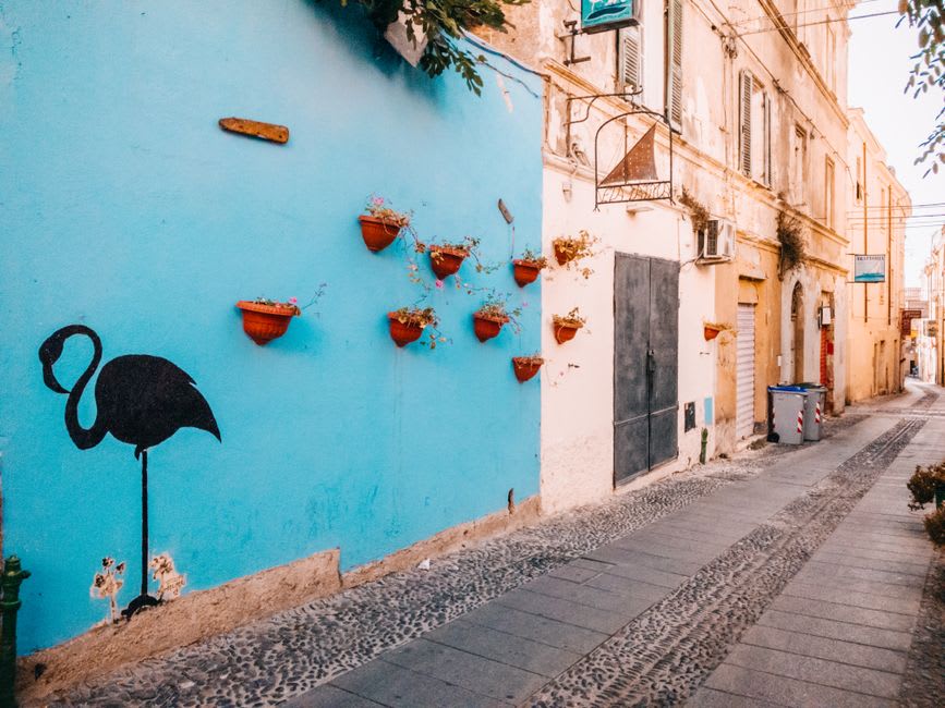 A narrow baroque street in Sassari's old town leading toward the Duomo di San Nicola facade