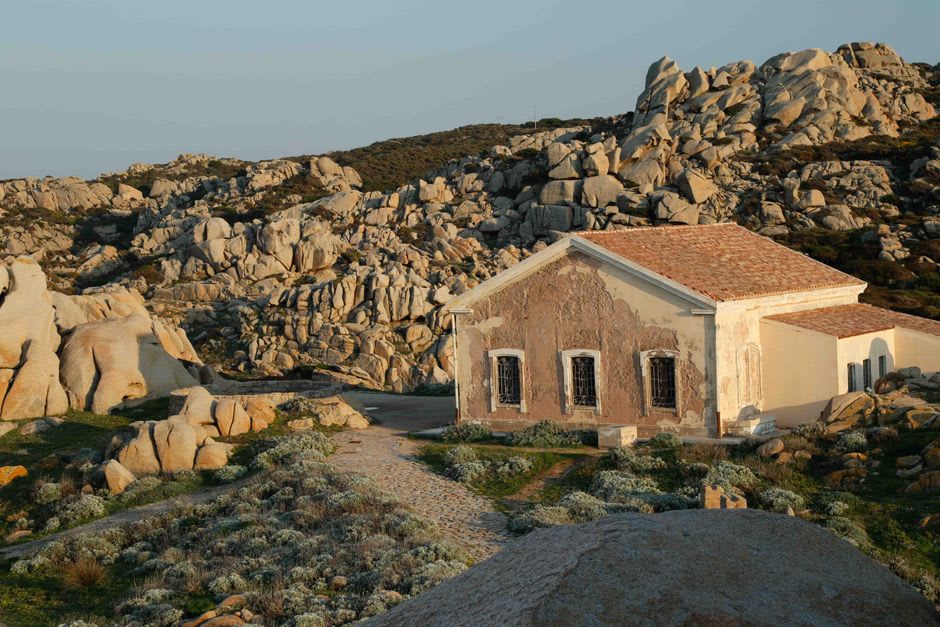La cuenca quieta y azul verdosa del manantial de Su Gologone rodeada de juncos y adelfas bajo los acantilados del Supramonte