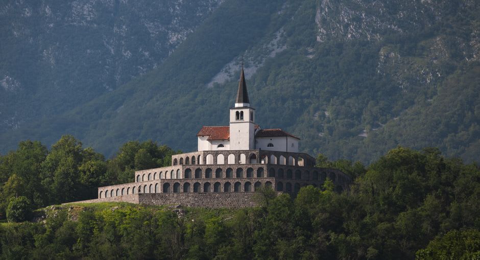 Filas de cruces blancas en un cementerio militar cubierto de hierba en la colina sobre Kobarid, con vistas al valle del Soča