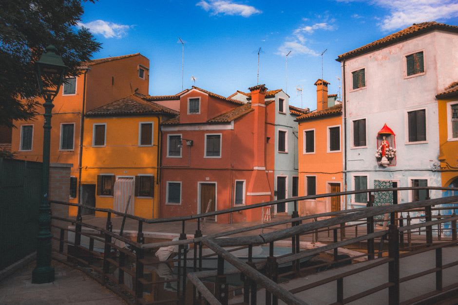 A quiet canal-side street in Trnovo lined with pastel houses and small local shops