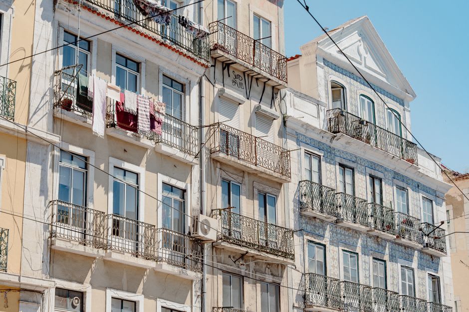 Calle modernista estrecha del casco antiguo de Sitges con balcones de hierro forjado y fachadas de azulejos