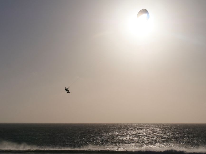 Colorful kitesurfing sails on the wind-whipped waters of Playa de los Lances near Tarifa