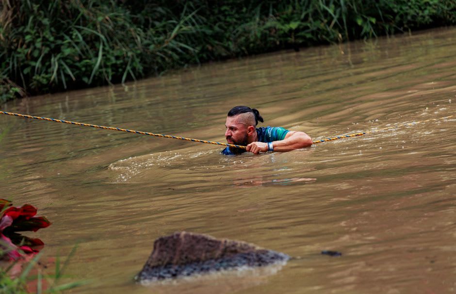 Trekking group crossing a shallow river on the trail near Buritaca