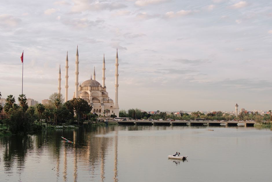 The illuminated Sabancı Central Mosque reflected in the Seyhan River at dusk