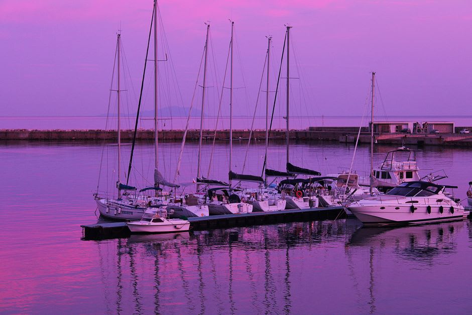 Sailboats and yachts moored in Çeşme's marina at sunset