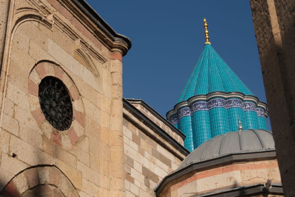 La cúpula acanalada turquesa del Museo Mevlana con peregrinos reunidos fuera
