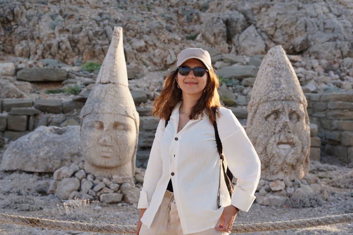 Colossal limestone heads of gods and kings arranged in a row on the East Terrace of Mount Nemrut, their worn faces glowing in the pale pre-dawn light