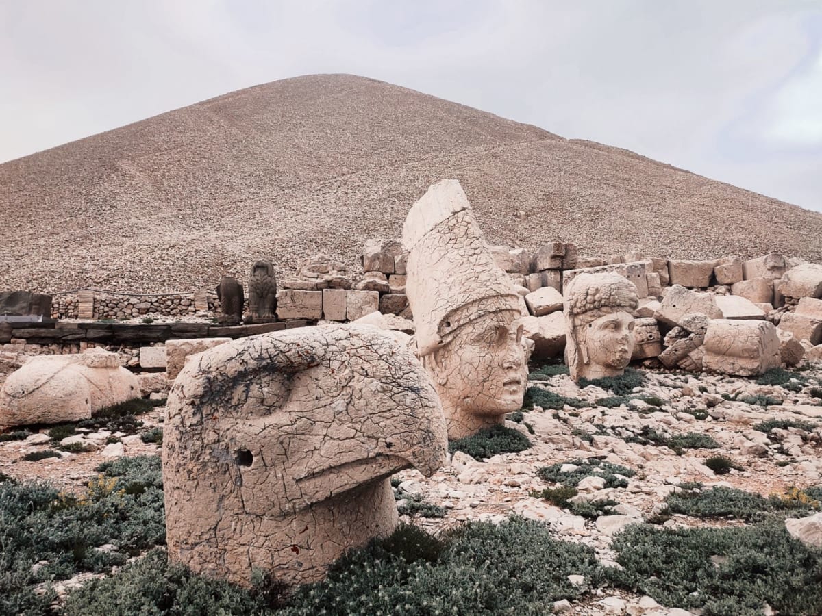 Pierre crouching beside the enormous limestone head of Zeus-Oromasdes, the worn bearded face nearly his height, with the Anatolian plateau stretching to the horizon behind