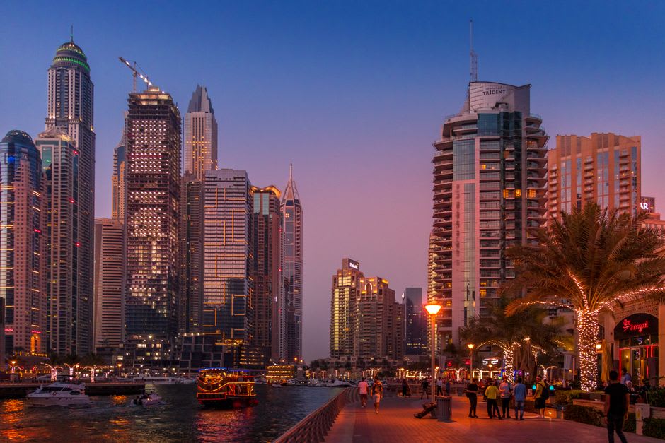 Promenade Marina Walk illuminée au crépuscule avec les tours se reflétant dans le canal