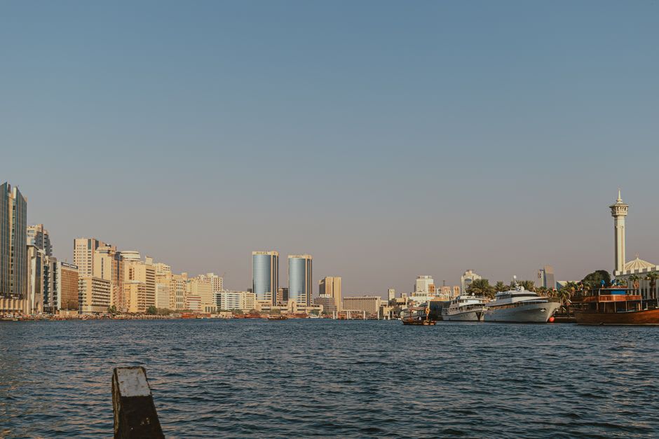 Un dhow traditionnel naviguant sur le canal illuminé de Dubai Marina la nuit