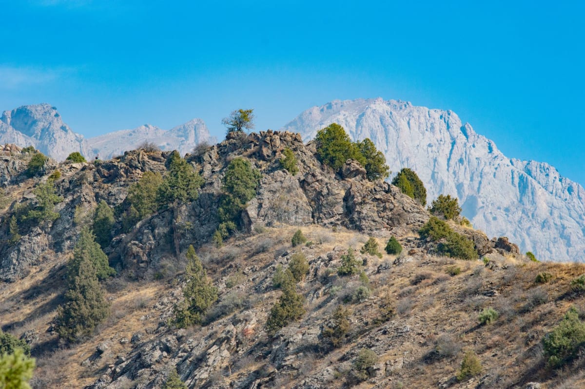 Un télésiège ouvert à une place de l'ère soviétique gravissant le flanc verdoyant de la montagne du Tchimgan avec des crêtes s'étirant au loin