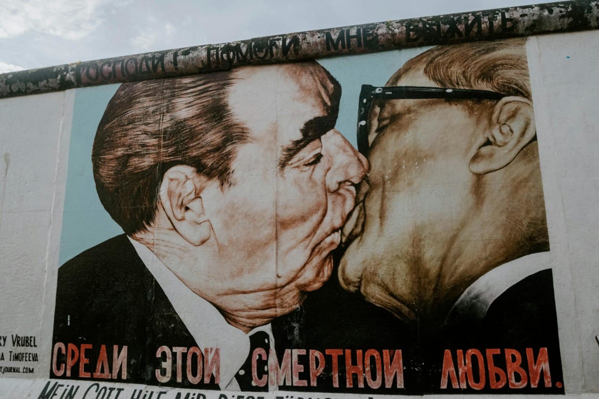 Murals on the East Side Gallery with the Spree River alongside