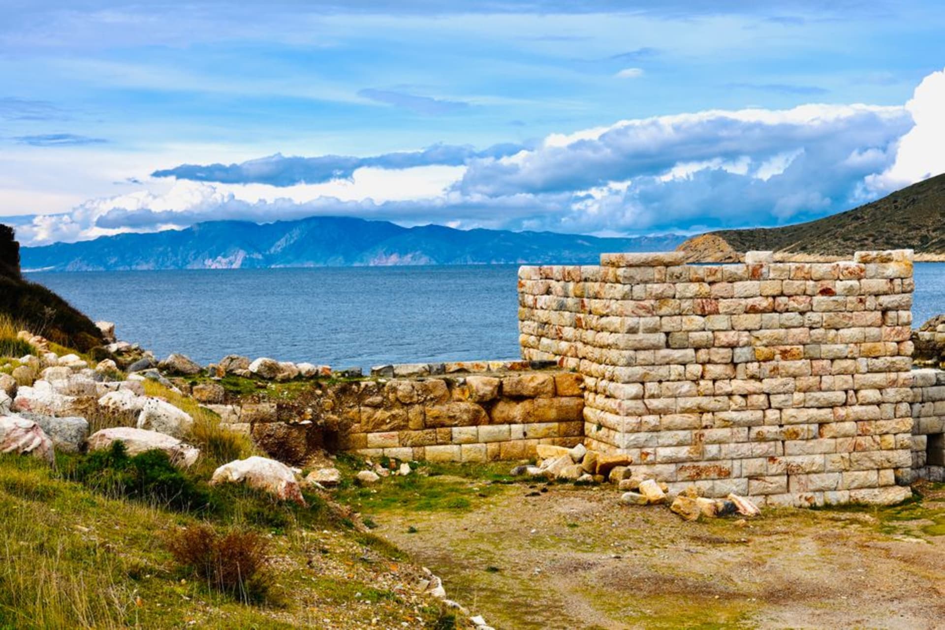 The twin harbors of ancient Knidos at the tip of the Datça peninsula with scattered ruins along the shoreline and the open Aegean beyond