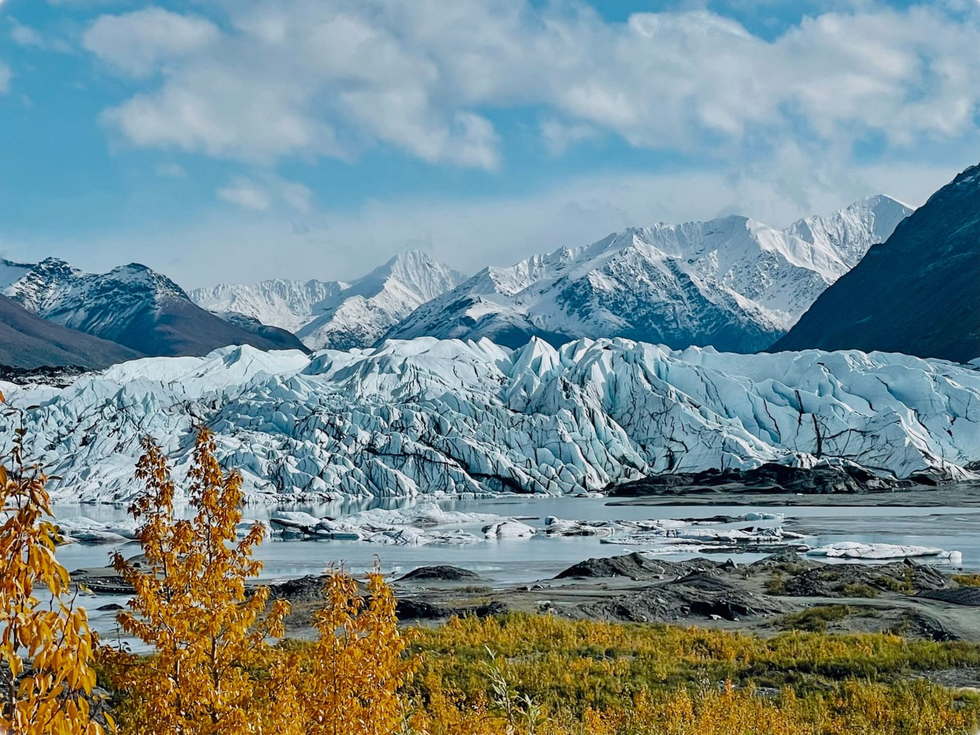 The red and white Kennecott copper mine buildings rising from the Wrangell Mountains above the Root Glacier, untouched wilderness all around