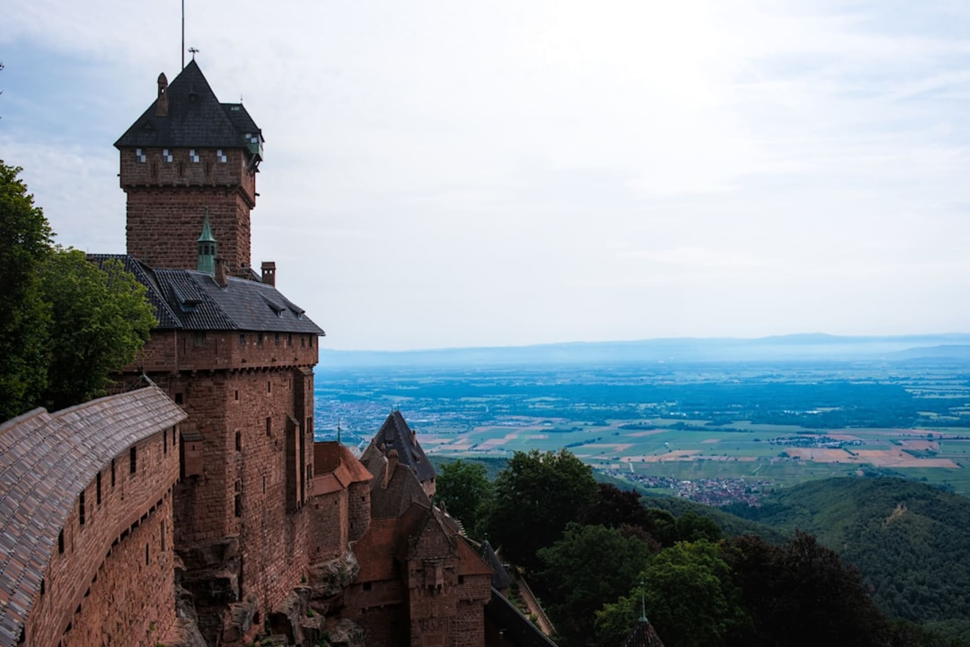 Chateau du Haut-Koenigsbourg encaramado sobre un espolón rocoso por encima del bosque de los Vosgos, visto desde abajo