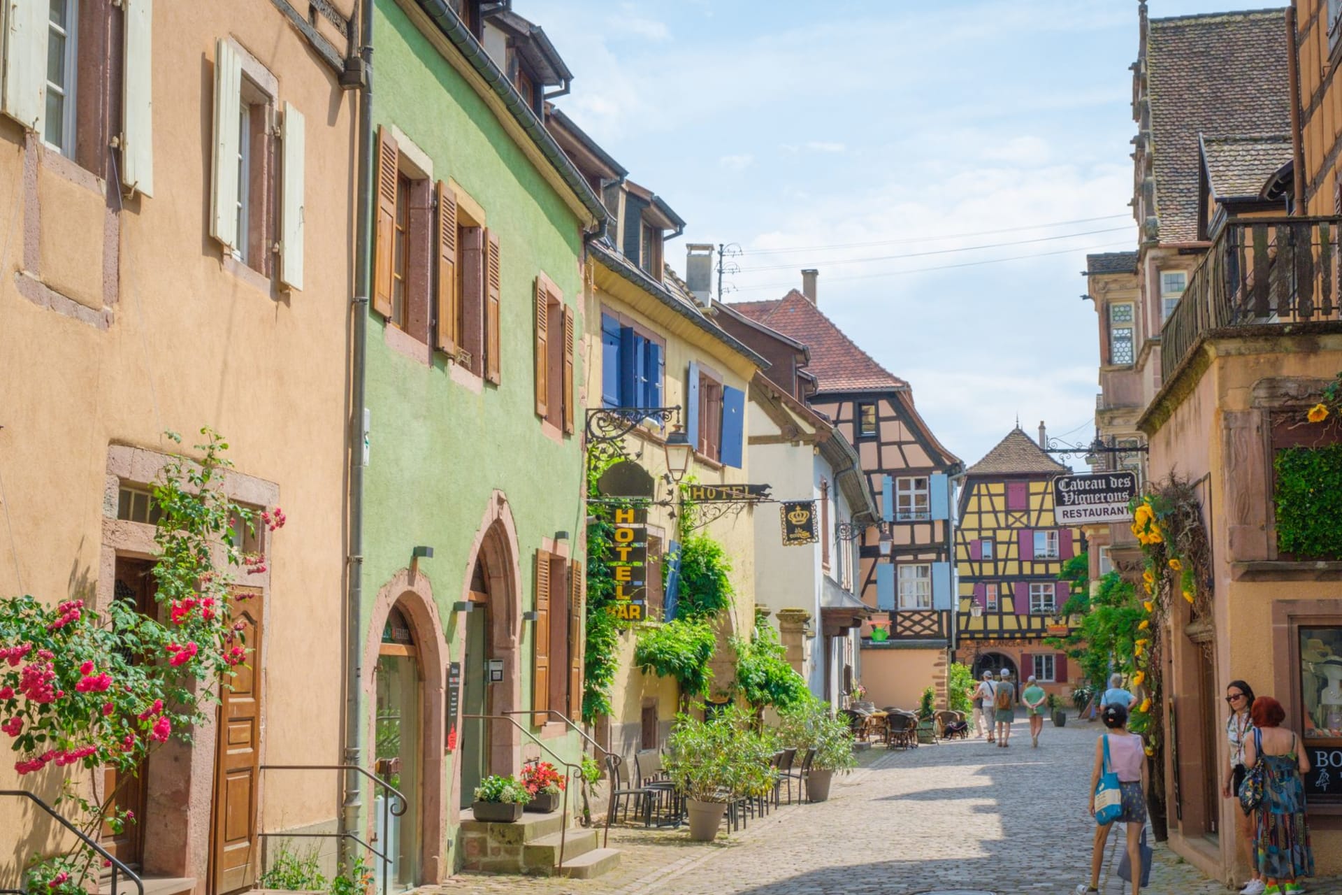 Riquewihr's medieval Dolder tower and colorful half-timbered houses rising above surrounding Riesling vineyards in autumn gold