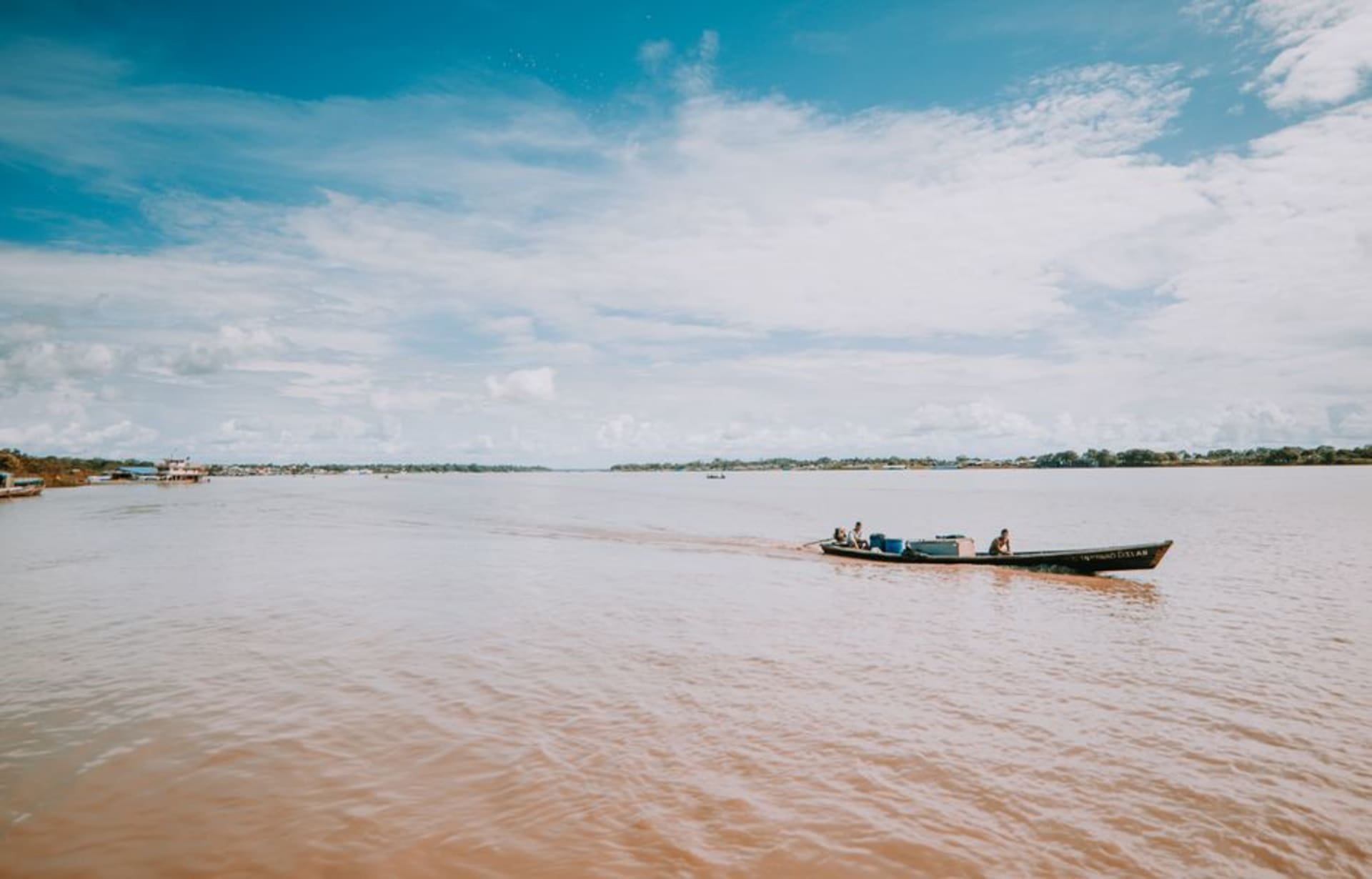 The riverfront of Leticia at dusk with wooden boats moored along the Amazon River