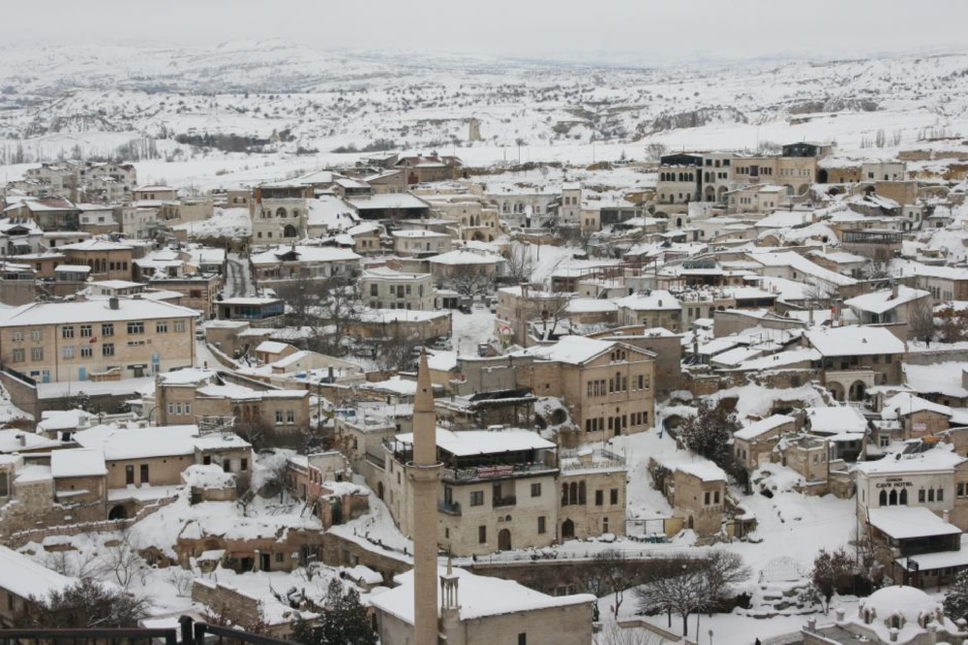 The town of Ürgüp with its stone houses and fairy chimney formations rising against a warm evening sky