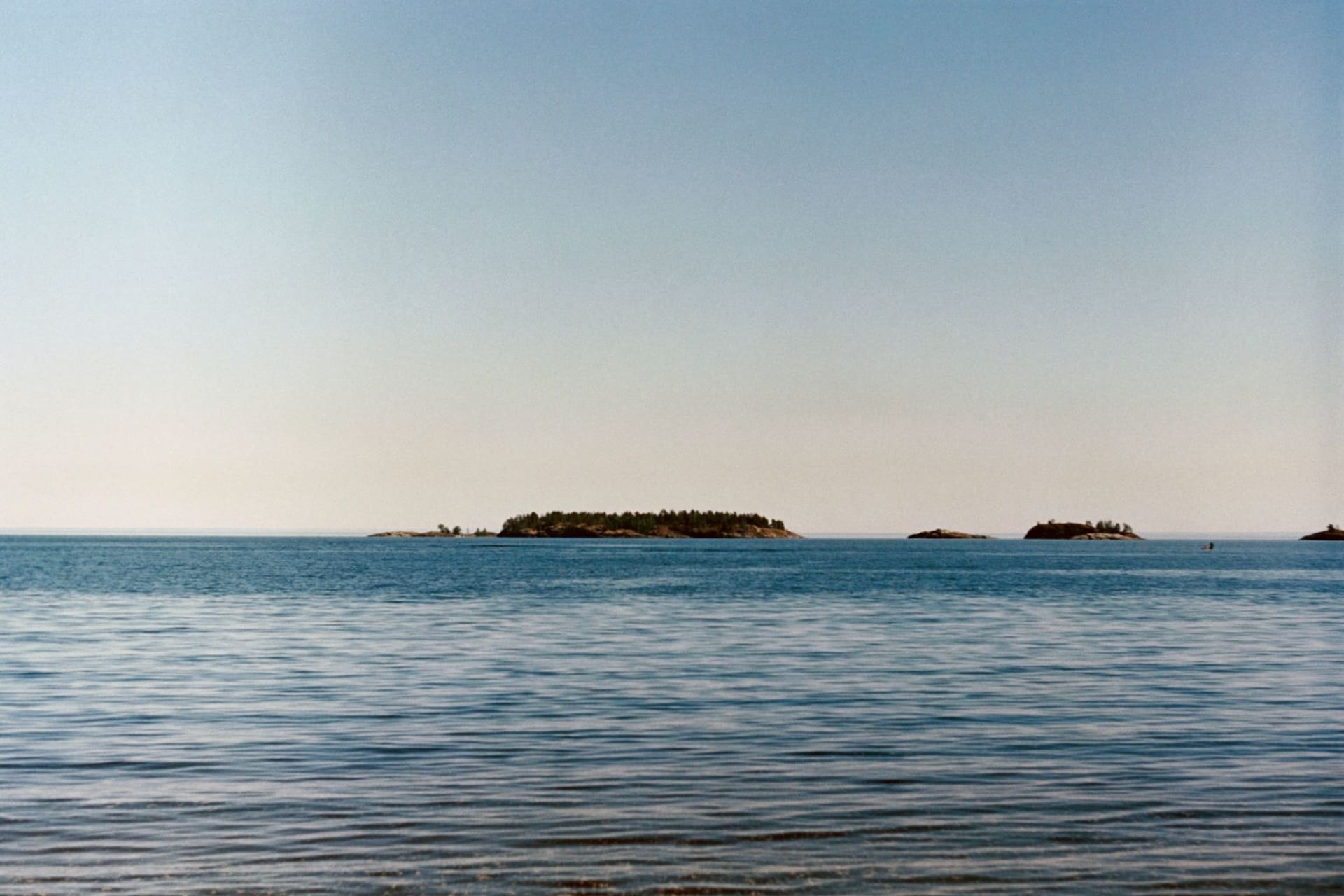 Lalaji Bay beach on Long Island with crystal-clear turquoise water and undisturbed forest reaching to the shore