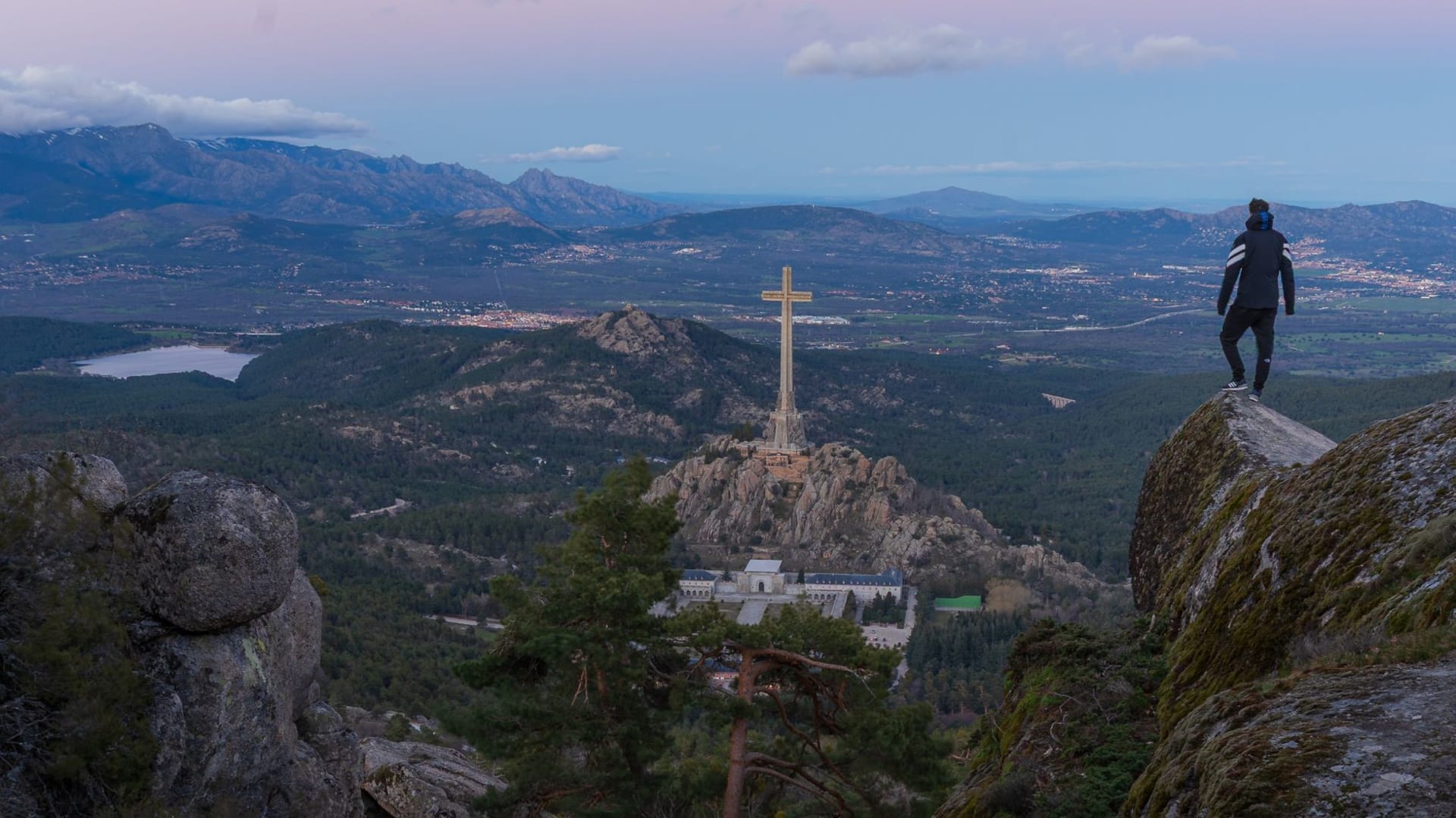 The wide glacially-carved Vall del Madriu with a turquoise high-altitude lake, granite boulders, and Pyrenean peaks under a summer sky