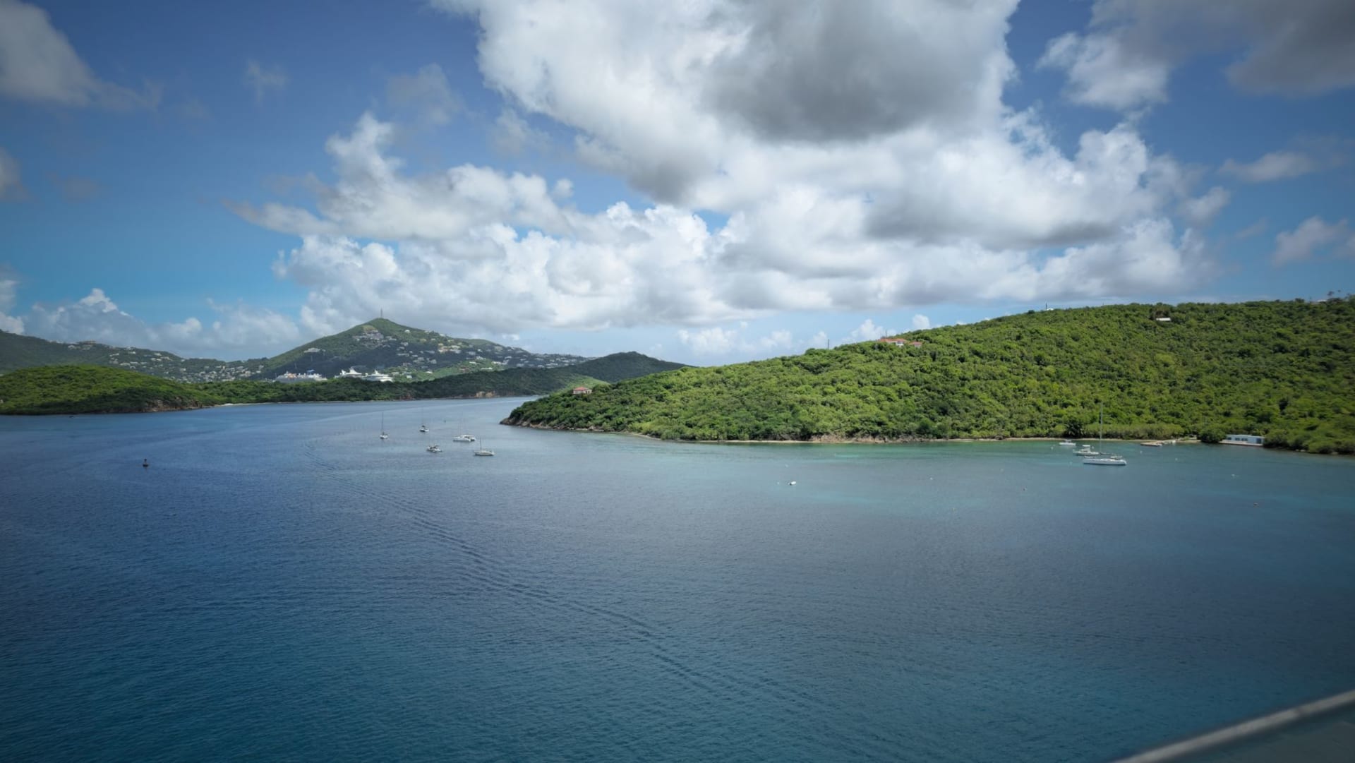 Scrub Island's wild, uninhabited shoreline seen from the water, limestone cliffs and scrubby vegetation with no human structures visible