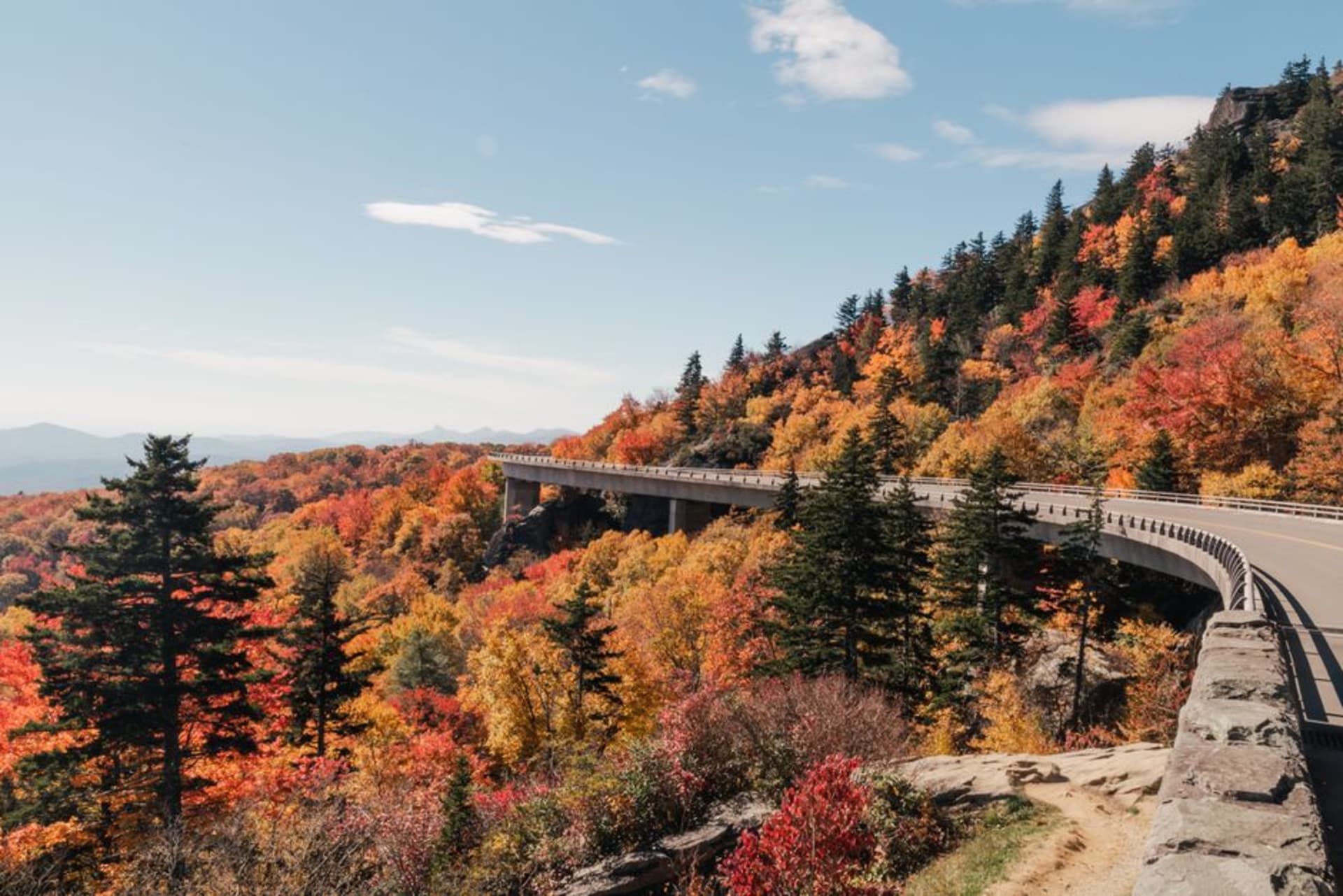 The Blue Ridge Parkway winding along a forested ridge under a hazy blue sky