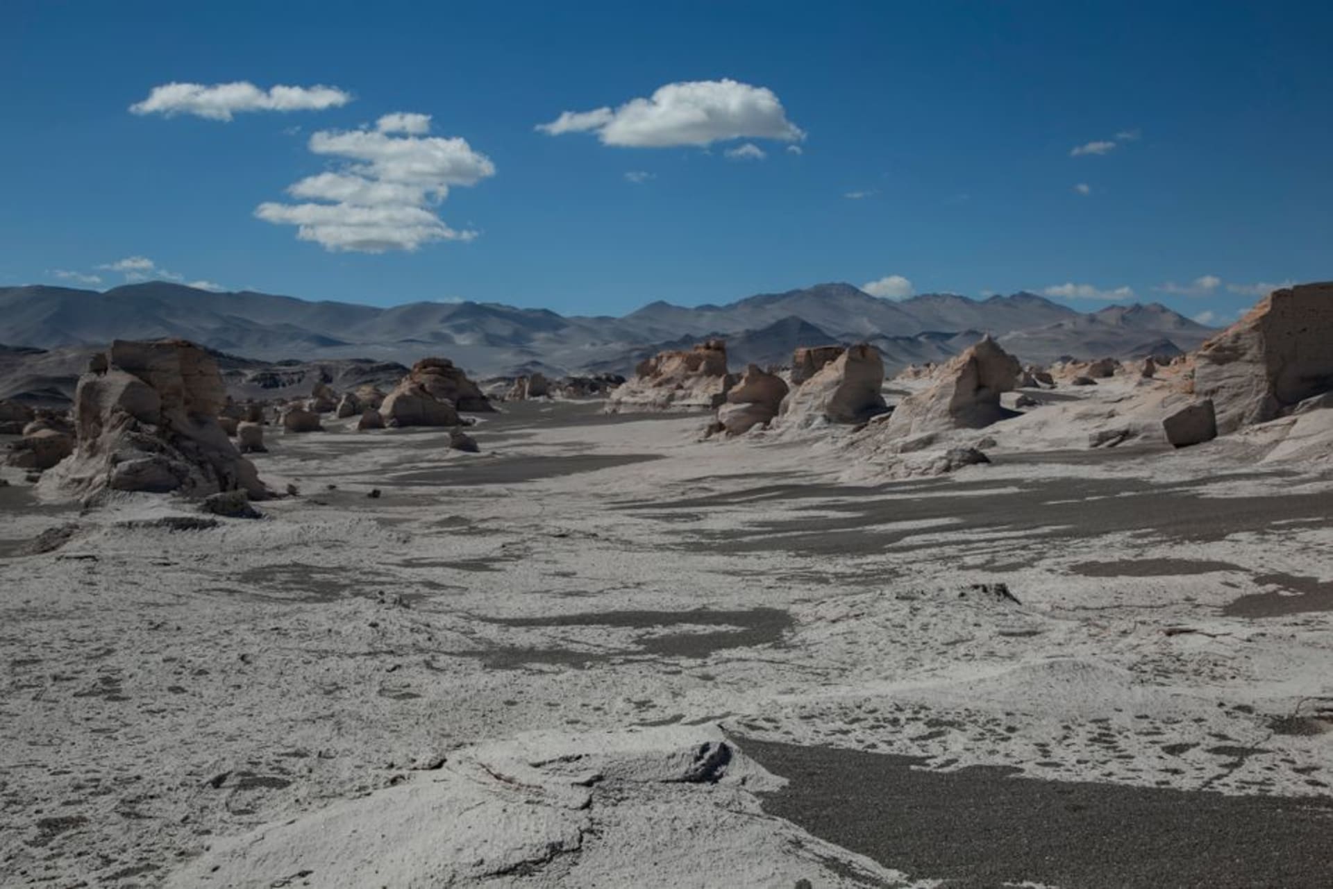 Pequeño pueblo de adobe de Antofagasta de la Sierra en la puna, con picos volcánicos y desierto vacío extendiéndose hasta el horizonte