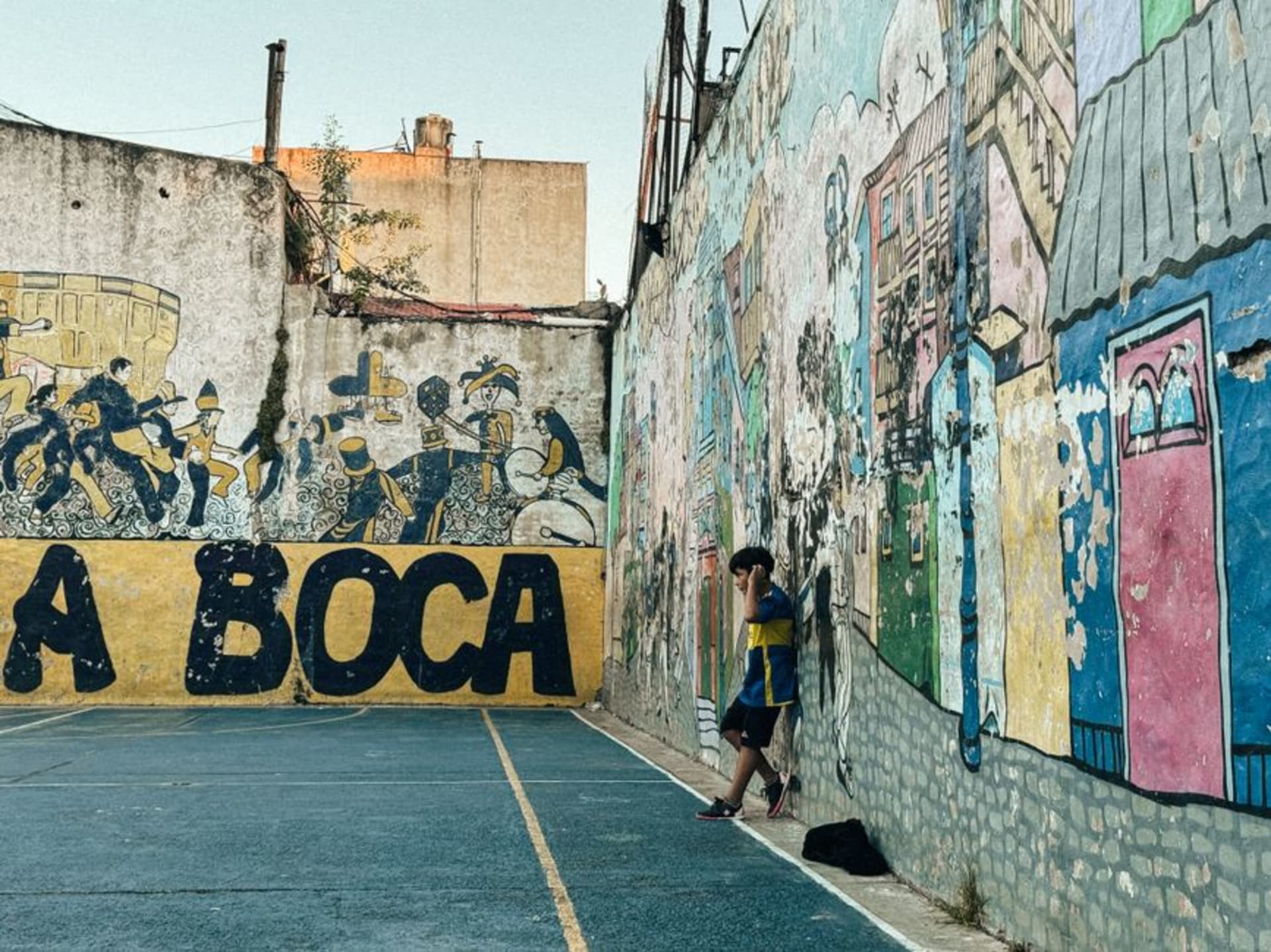 Casas de chapa corrugada pintadas en rojos, azules y amarillos vibrantes a lo largo de la calle Caminito en La Boca, Buenos Aires