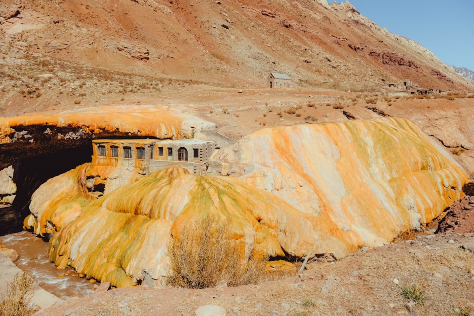 Puente de roca natural teñido de amarillo y naranja por aguas termales minerales en Puente del Inca, en los Andes, Argentina