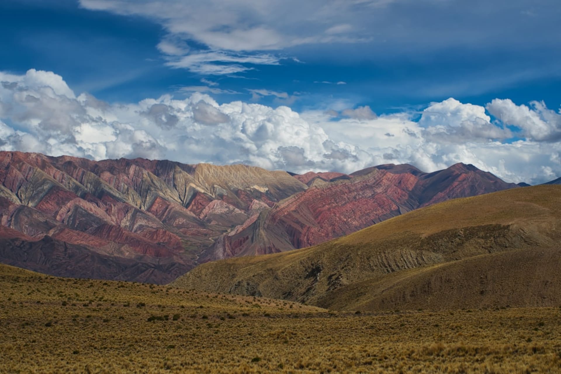 El Tren a las Nubes cruzando el curvo viaducto de La Polvorilla en lo alto de los Andes contra un cielo azul profundo