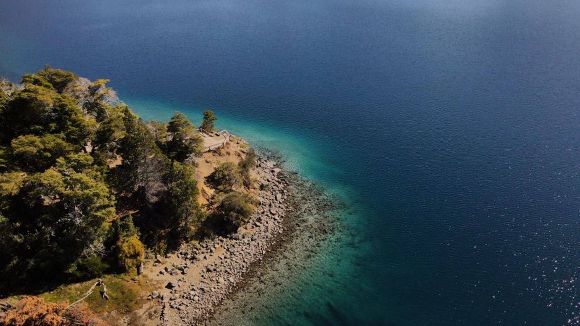 Turquoise waters of Lago Traful surrounded by steep forested mountains