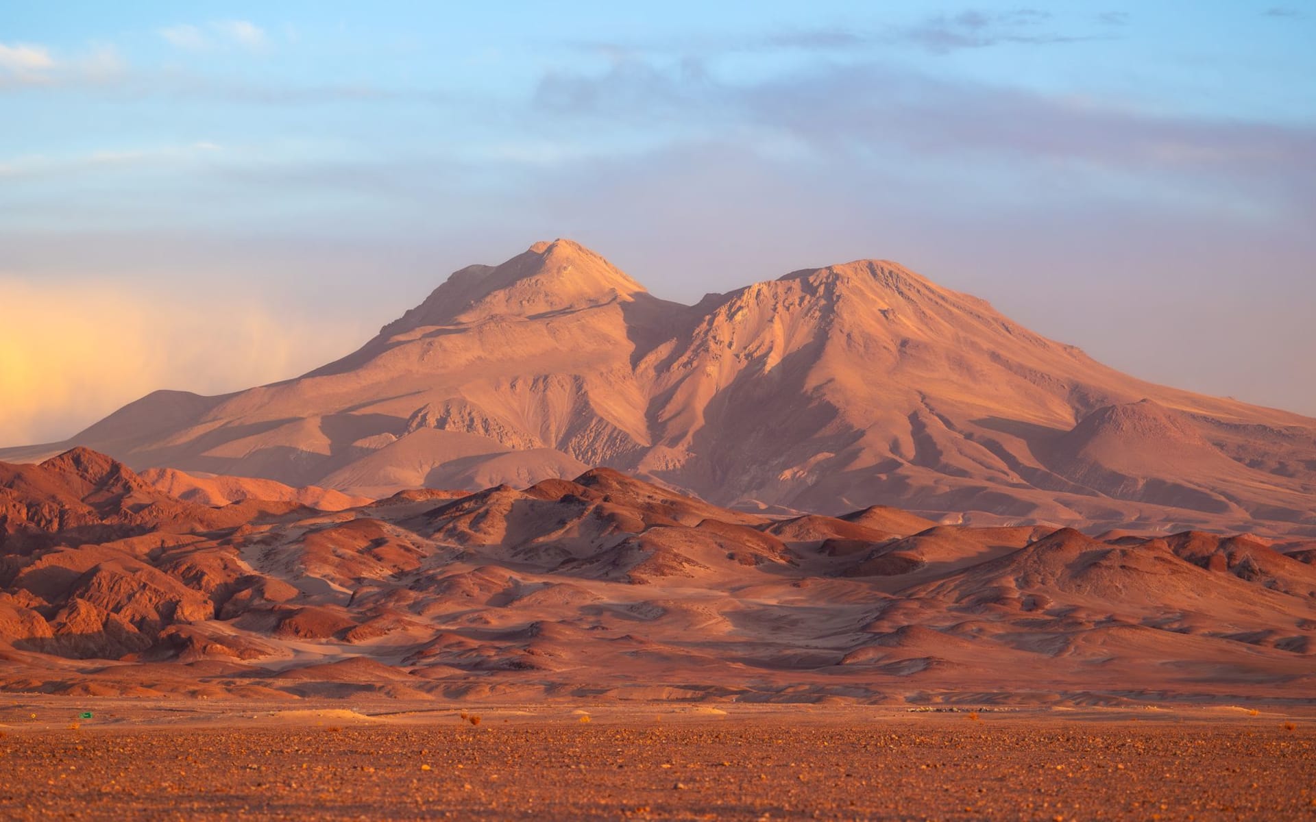 The vast white expanse of the Salar de Atacama stretching to the Andes under a deep blue sky with salt polygon patterns in the foreground