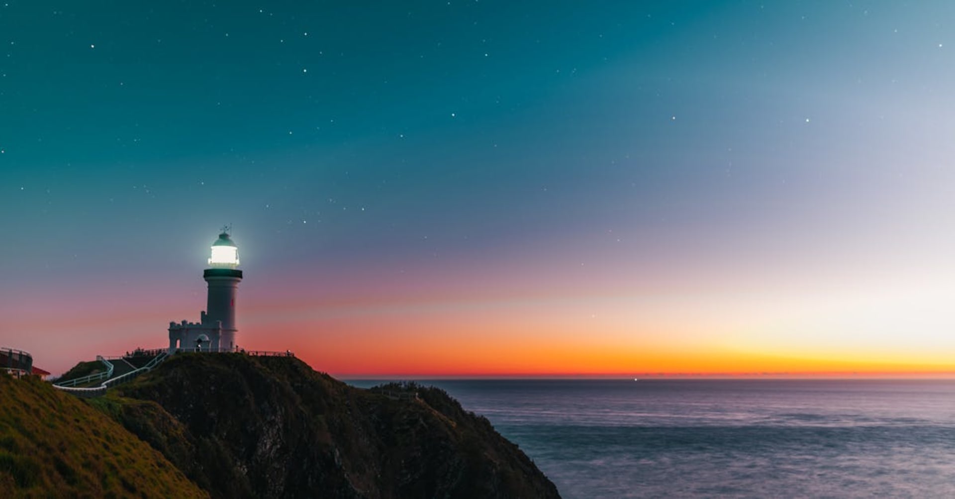 Byron Bay lighthouse on the headland with the coastline stretching behind