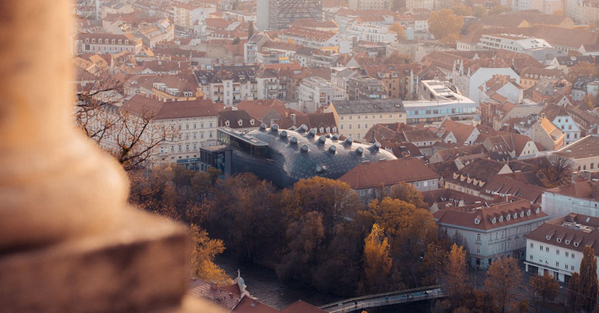 Red rooftops of Graz's old town viewed from the Schlossberg hill with the clock tower in foreground