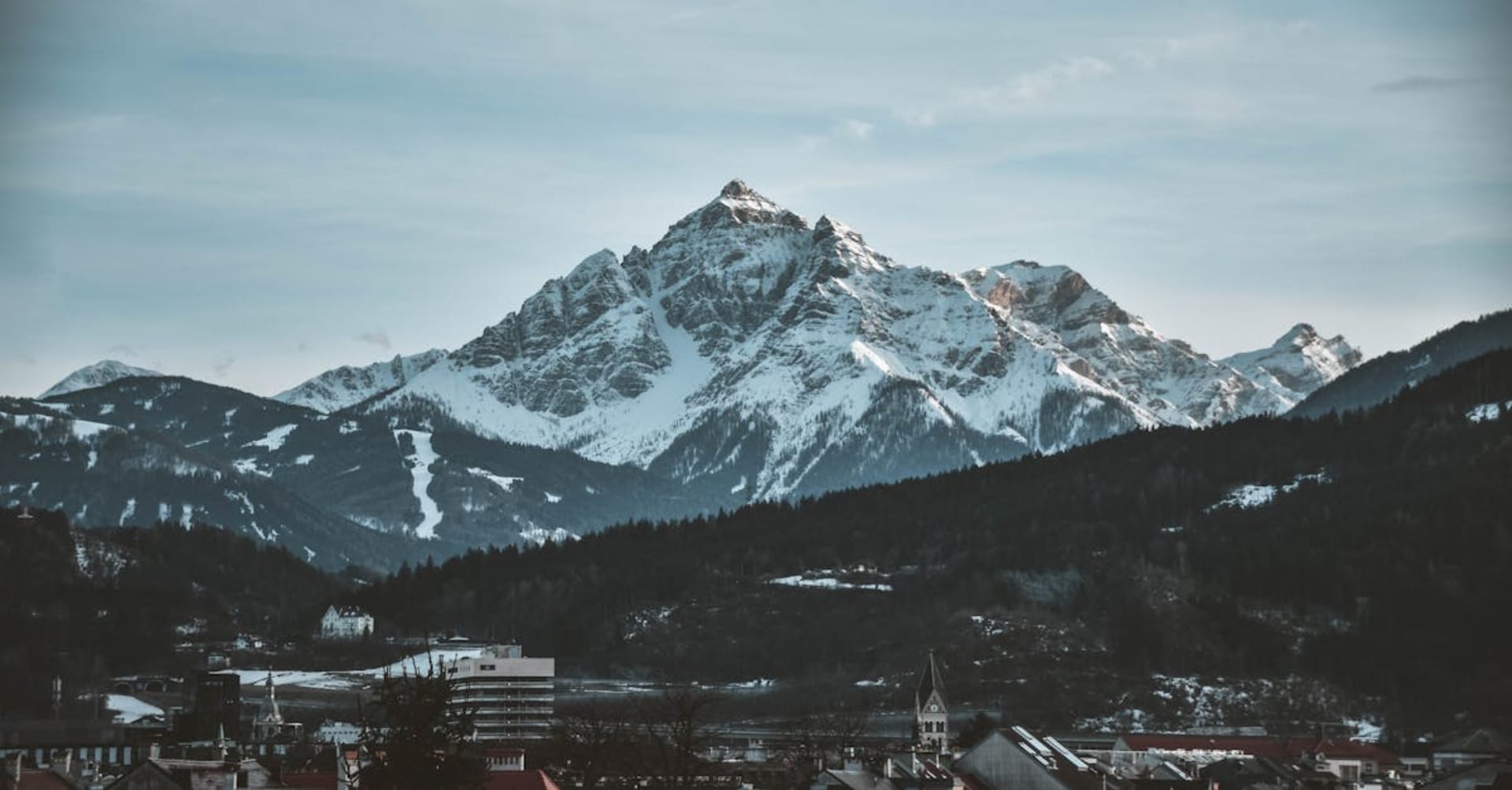 Innsbruck's colorful old town buildings with the snow-covered Nordkette mountains rising directly behind