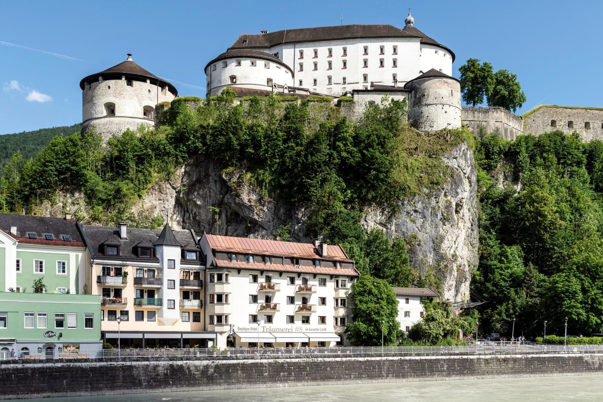 Kufstein's medieval Festung rising dramatically on a limestone cliff above the Inn river, the old town clustered at its base and the Bavarian hills visible across the water